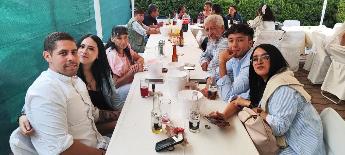 Comensales conviviendo en una mesa larga durante un evento de Casa José